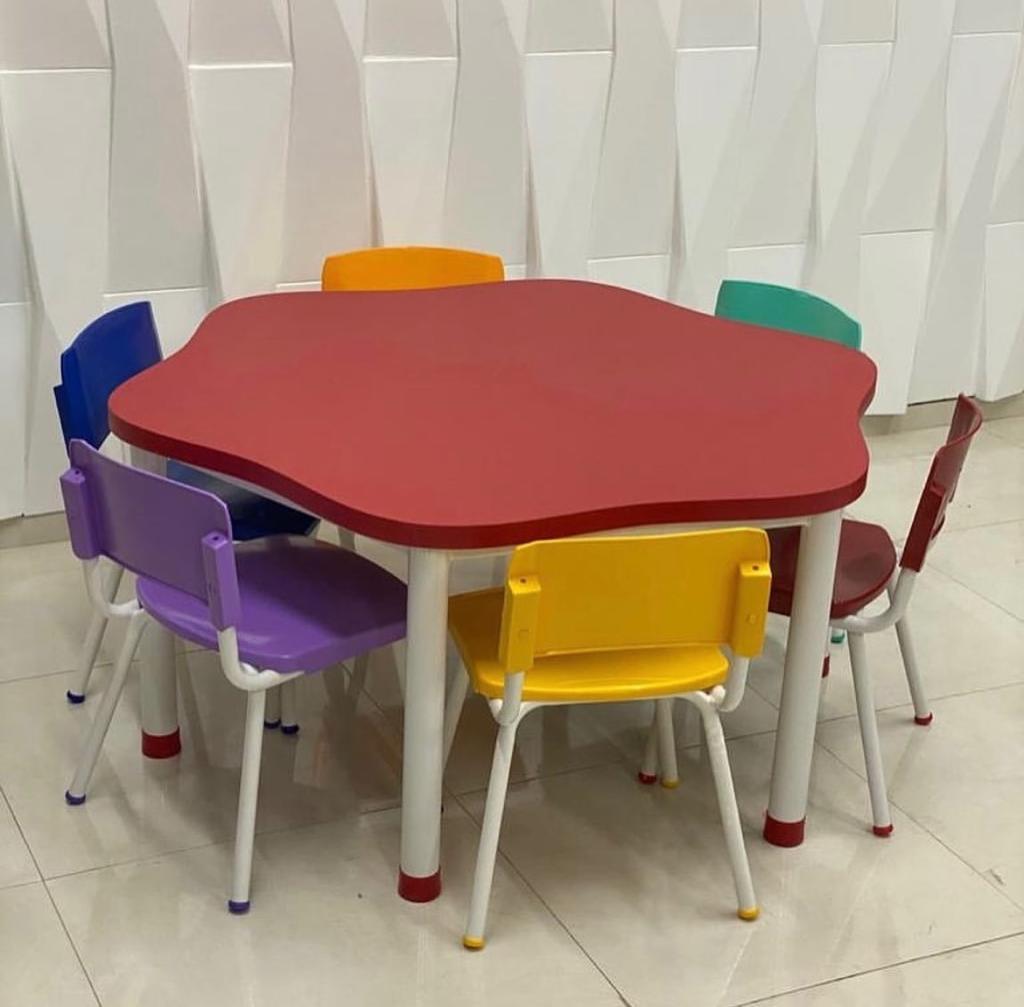 Mesa escolar infantil vermelha com cadeiras coloridas
