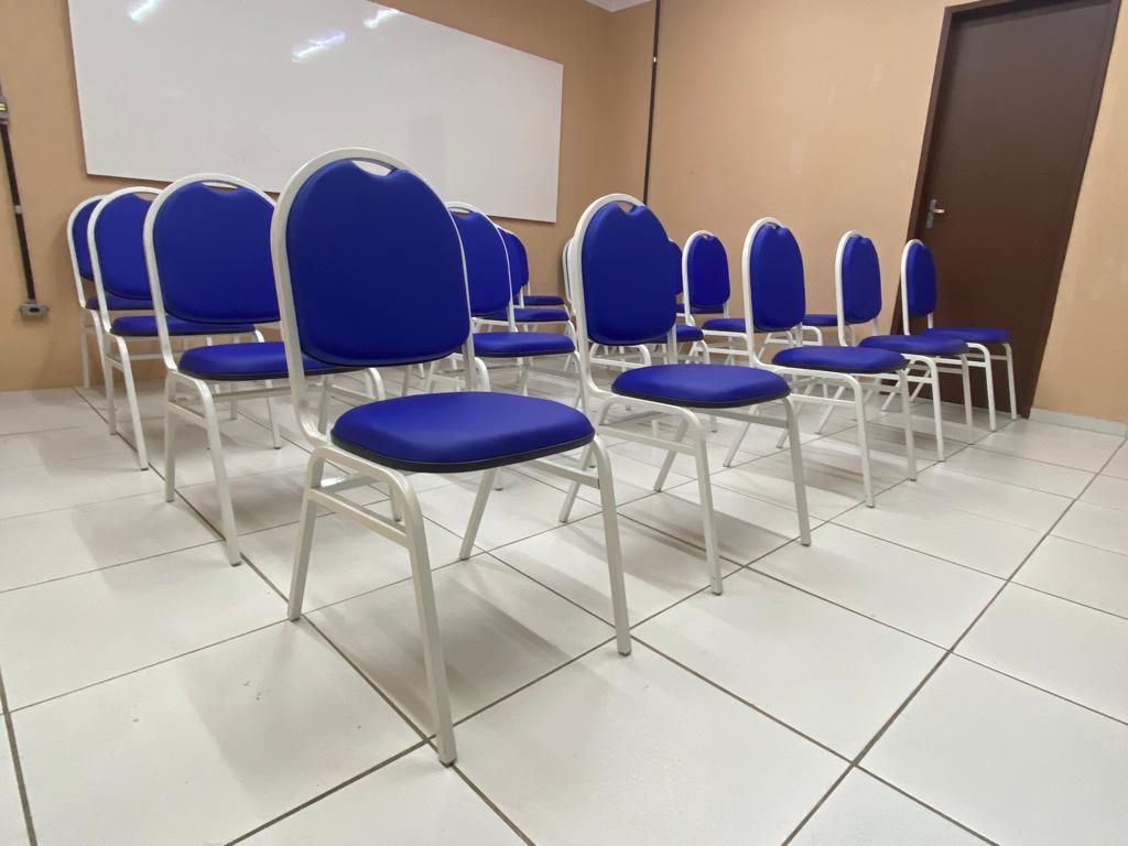 Cadeiras escolares azuis em sala de treinamento